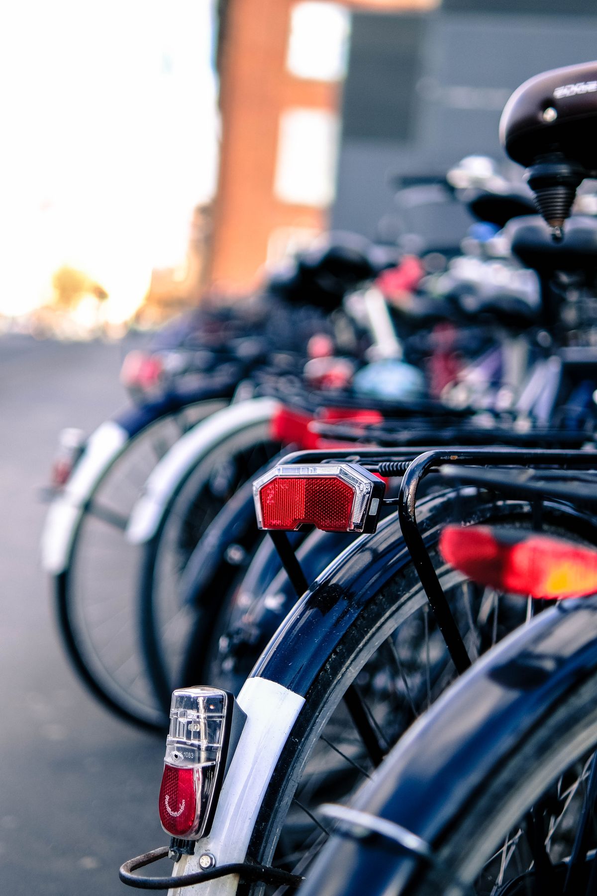 夕方の街に並んで停められた自転車の後輪
